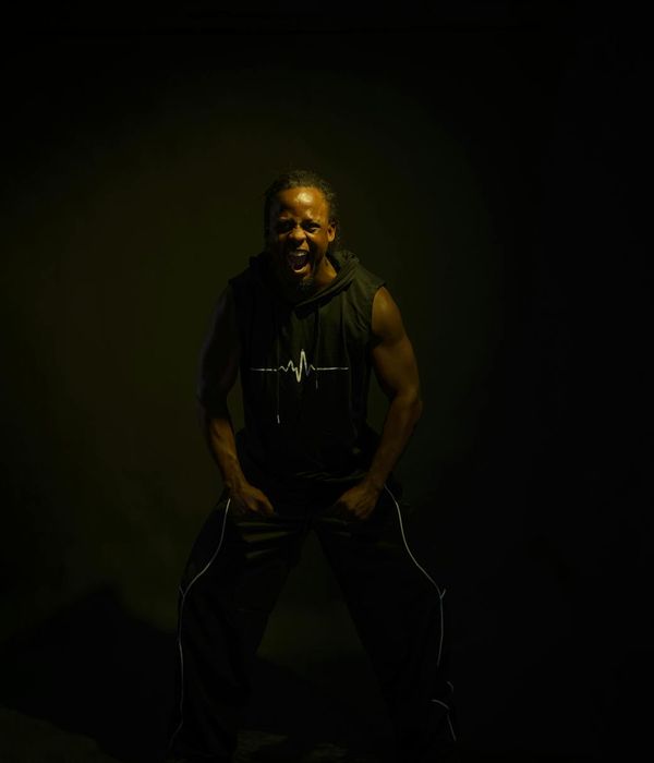 Woman in a dynamic cardio pose against a dark background.